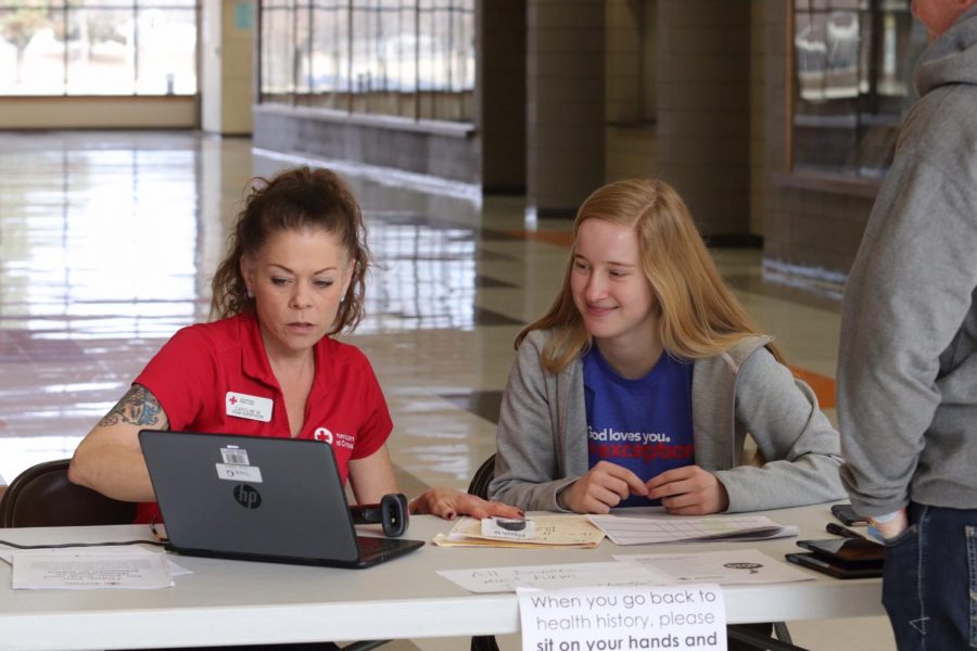 Senior Beth Holmes works with a Red Cross worker at a blood drive earlier this year. 